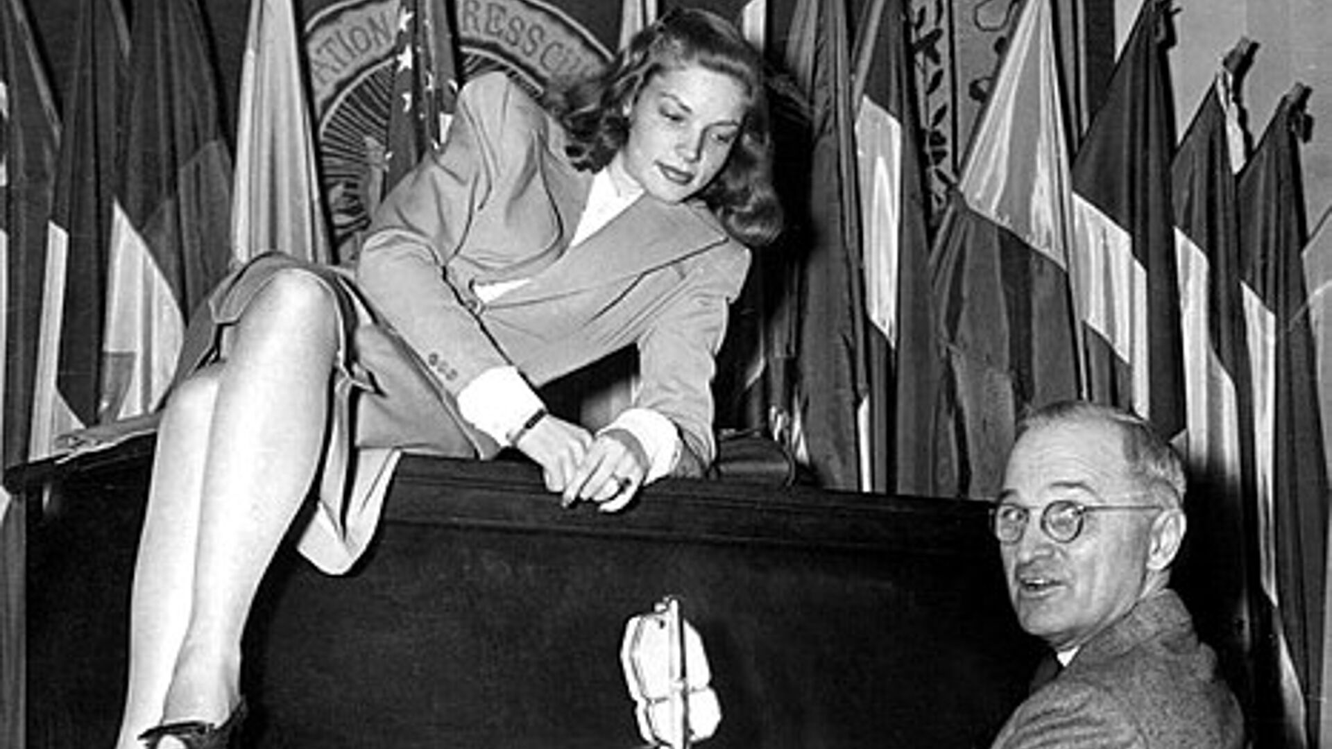 President Truman playing the piano with actress Lauren Bacall